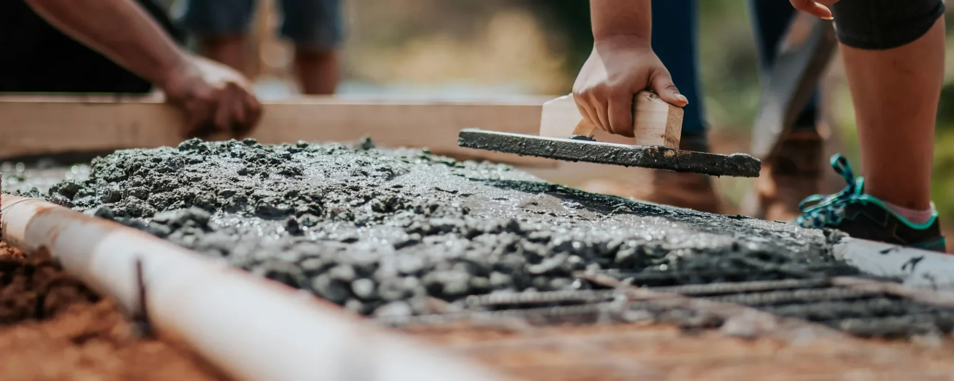 Nahaufnahme einer Baustelle, auf der Beton geglättet wird. Perfekt für Inhalte über Bau, Handwerk und DIY-Projekte.
