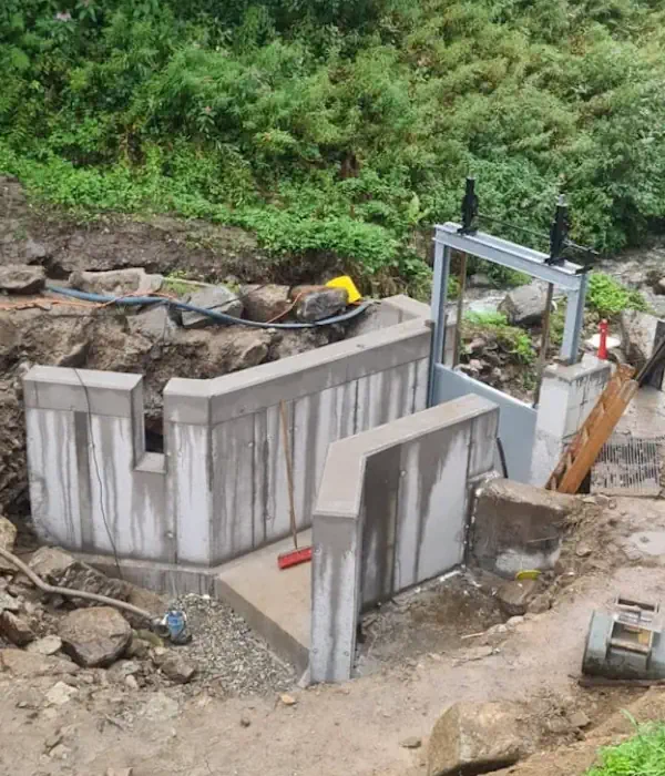 Bild zeigt eine unvollständige Brücke mit Betonstruktur in einer ländlichen Umgebung, Baustelle mit Vegetation im Hintergrund.