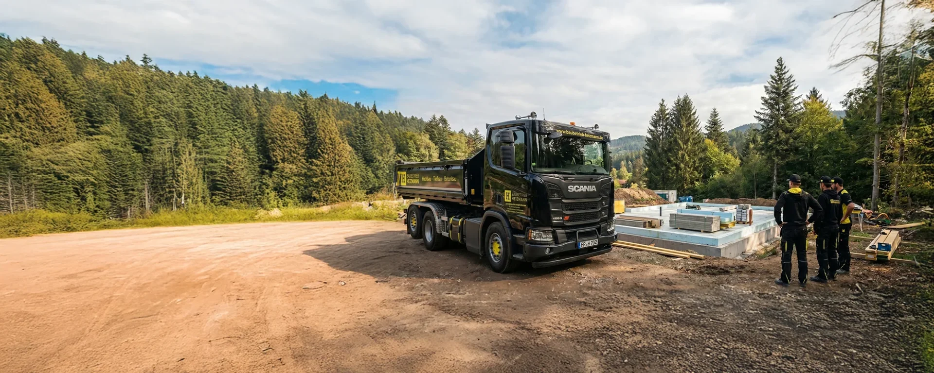 Bau-LKW im Wald, Baustelle im Hintergrund, Team in Arbeitskleidung beobachtet Fortschritt. Perfekte Szene für Bauunternehmen und Nachhaltigkeit.